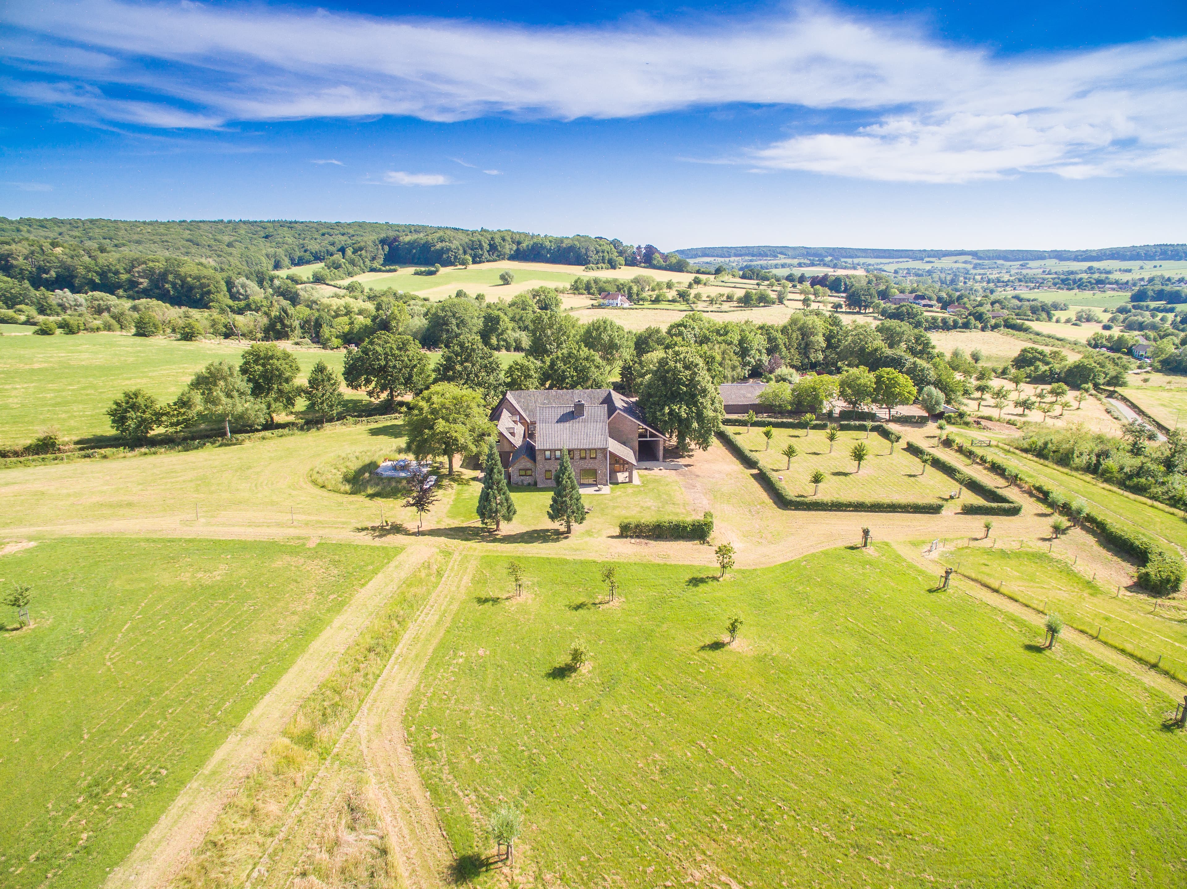 Hoeve 1700 vanuit de lucht, met moestuin en boomgaard in glooiend heuvelland